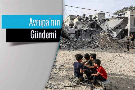 Gazze'de enkaza dönen binaların önünde oturan 4 çocuk