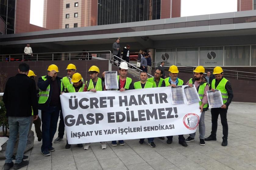 Ödenmeyen ücretleri için  eylem yapan inşaat işçileri basın açıklaması yaparken