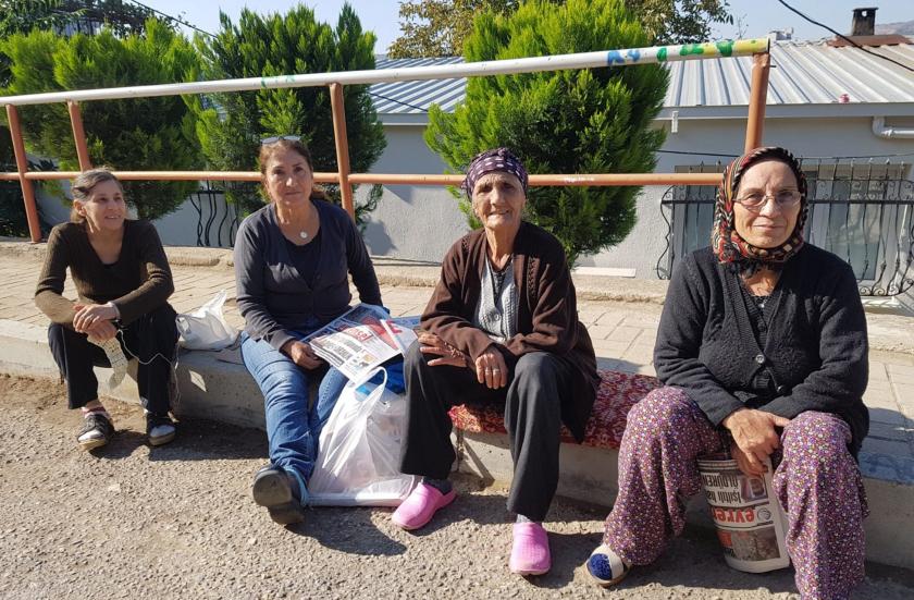 Haberde görüşleri yer alan dört kadın, kaldırımda oturmuş.