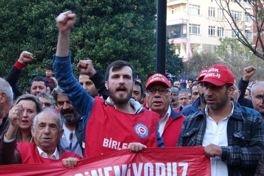 DİSK üyesi bir işçi basın açıklaması sırasında yumruğunu havaya kaldırarak slogan atarken