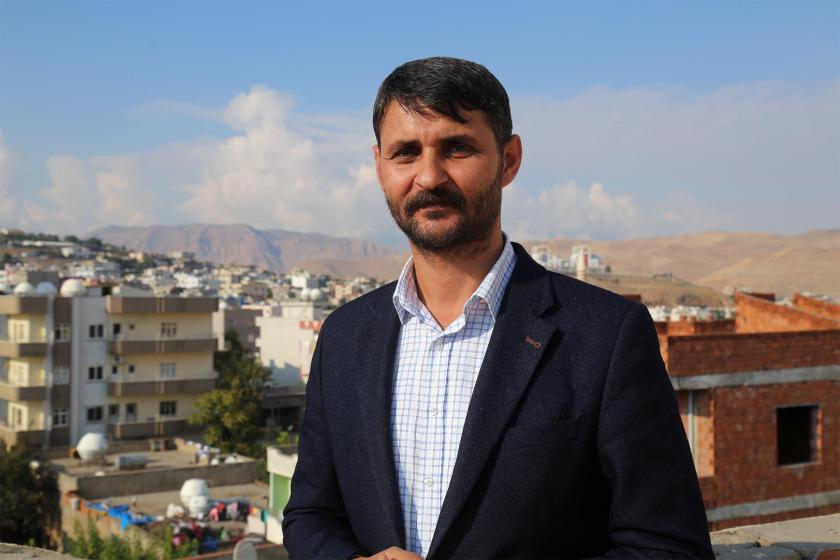 Görevden alınan Cizre Belediyesi Eş Başkanı Mehmet Zırığ ve ardında Cizre semaları