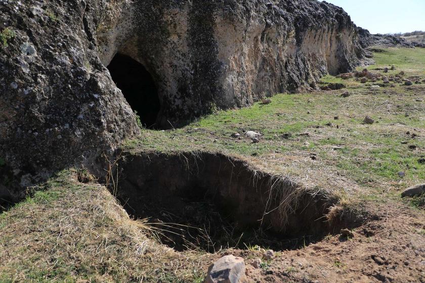 Diyarbakır'ın Eğil ilçesinde bulunan tarihi mağaranın önünde büyük bir çukur görünüyor. 