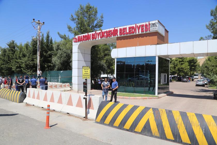 Mardin Büyükşehir Belediyesine kayyum atanmasının ardından belediye girişine konan polis barikatları ve barikatın ardında bekleyen polisler