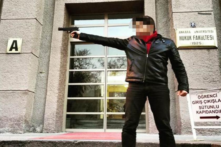 Yüzü blurlanmış M.A.V. isimli öğrenci Ankara Üniversitesi Hukuk Fakültesi önünde Siyasal Bilgiler Fakültesine silah doğrultuyor.