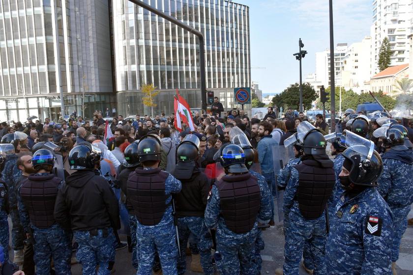 Lübnan'da protesto için toplanan halk ve onları çevreleyen polisler