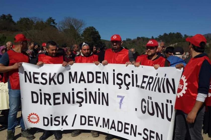 İşçiler DİSK önlükleriyle birlikte, üzerinde 