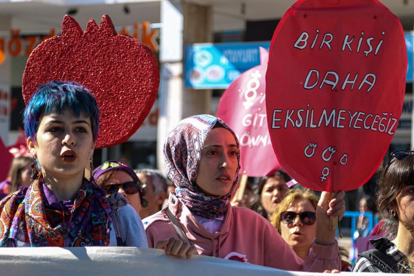 Bir kişi daha eksilmeyeceğiz yazılı döviz ve iki kadın