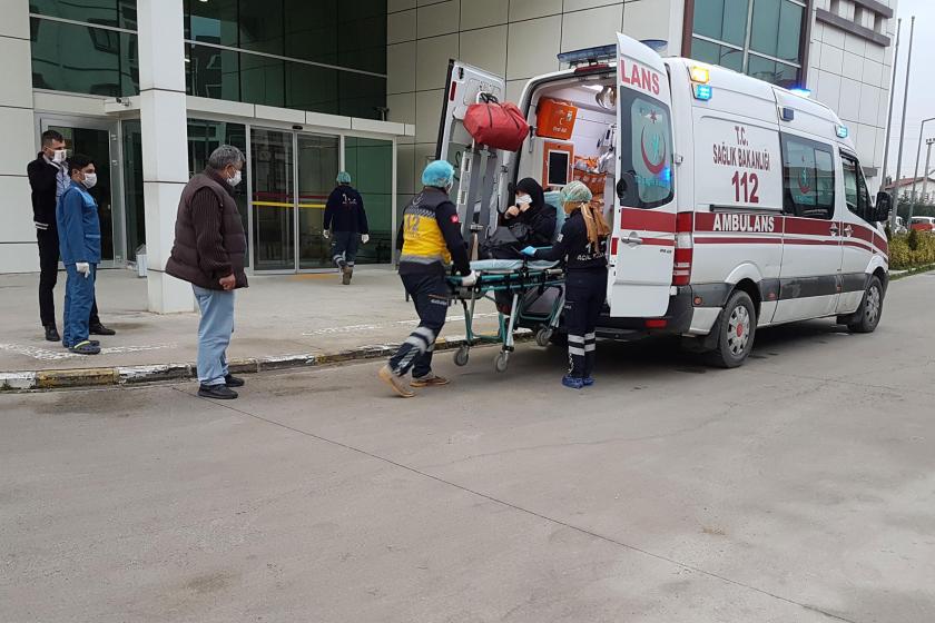 Koronavirüs şüphesiyle hastaneye kaldırılan kadın, sağlık çalışanları ve ambulans (sağda)