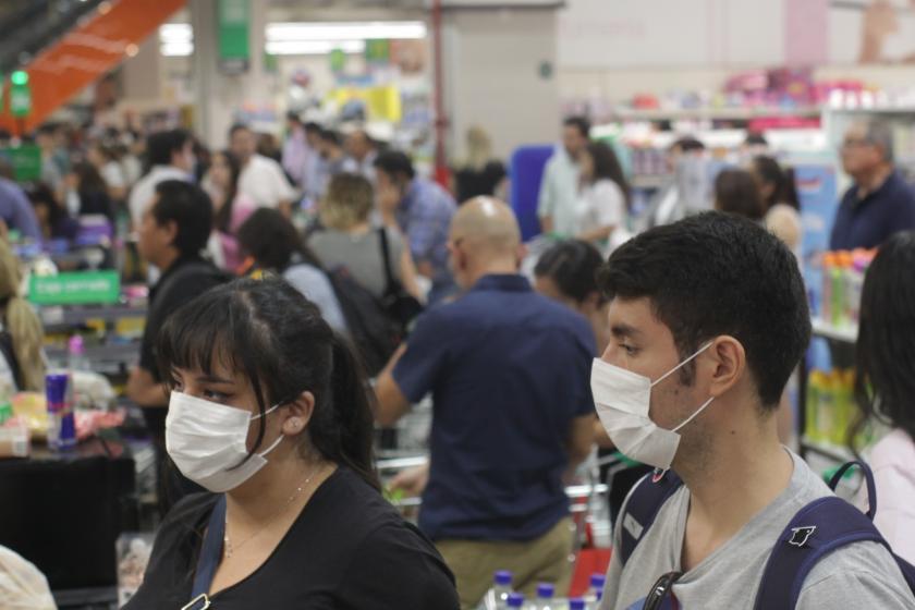 Şili'de ağızlarında maske olan insanlar marketten alışveriş yapıyor. 