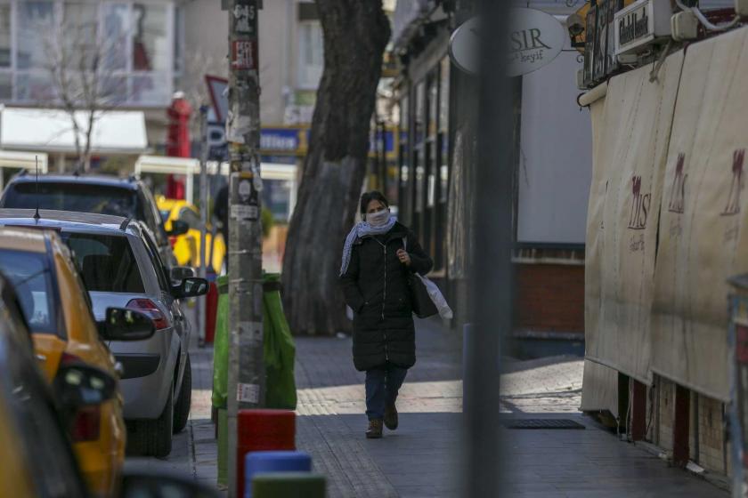 Ankara'da tenha caddede ağzı ve burnu kapalı halde yürüyen bir kadın.