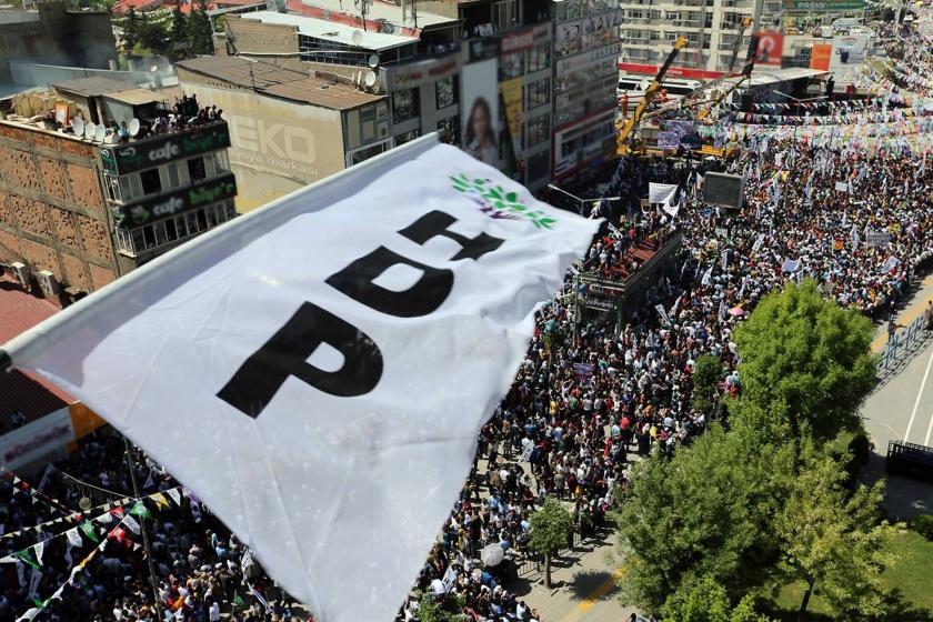 HDP mitinginden bir görünüm; yüksek bir kattan çekilmiş HDP bayrağı, altta kalabalık kitle var.