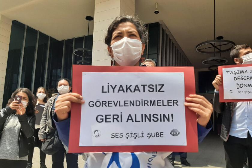 Sağlık emekçisi bir kadın elinde liyakatsız görevlendirmeler geri alınsın yazılı bir döviz tutuyor