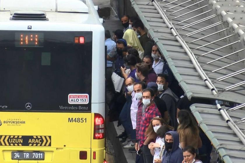 Metrobüs durağında bekleyen maske takmış çok sayıda kişi.