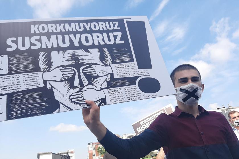 Korkmuyoruz susmuyoruz yazılı dövizi tutan genç bir erkek