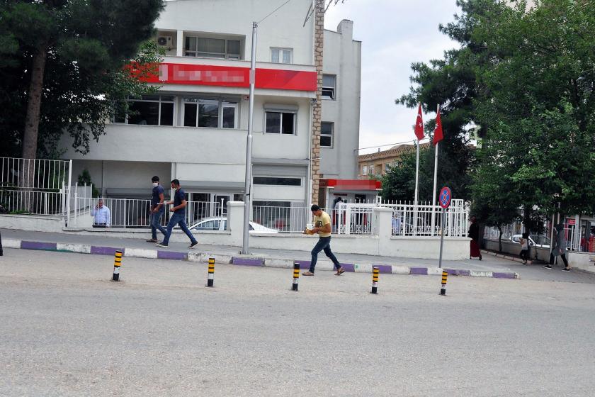 Banka şubesi ve önünde geçen 3 kişi