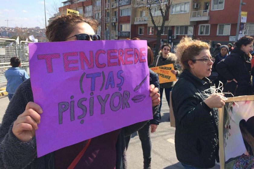 Tencerede taş pişiyor yazılı dövizi tutan bir kadın