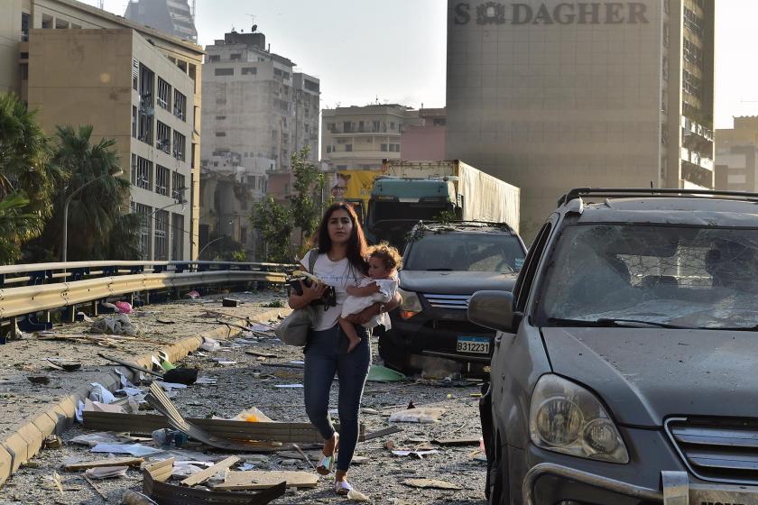 Patlama sonrası çocuğunu taşıyan bir kadın