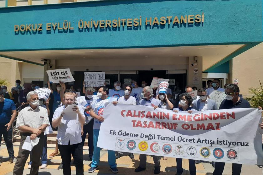 Dokuz Eylül Üniversitesi Hastanesi tabelası (yukarıda) önünde sağlık çalışanları basın açıklaması yapıyor