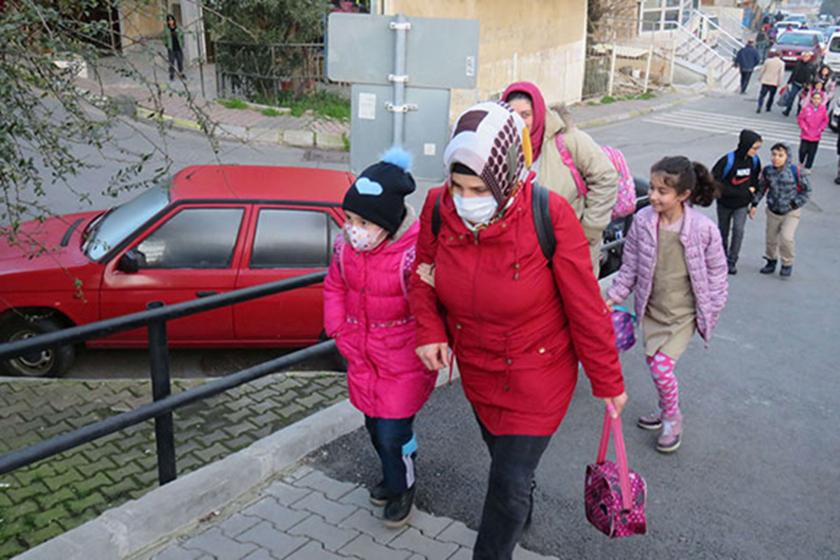 Maskesi takılı çocuklar, ellerinden tutan anneleri ile yürüyor