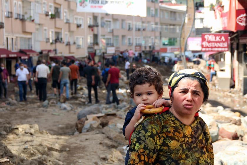 Giresun'da sel sonrası enkaz arasında çocuğunu sırtında taşıyan kadın