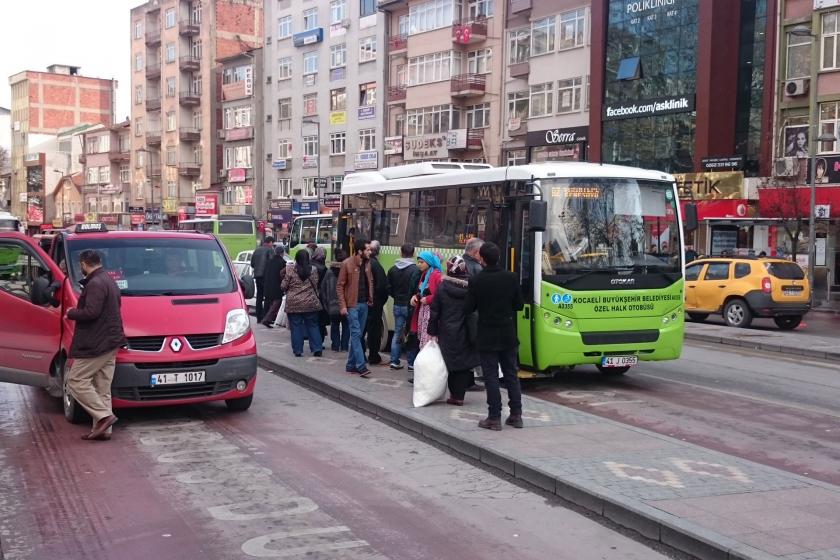 Kocaeli'de bir halk otobüsü (sağda), binmek için sıra bekleyenler