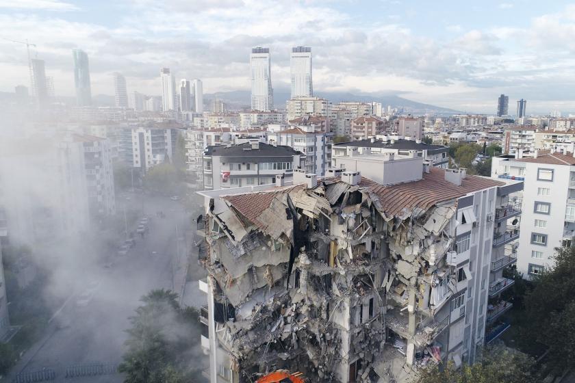 Depremde yıkılmış bina, arkasında gökdelenler