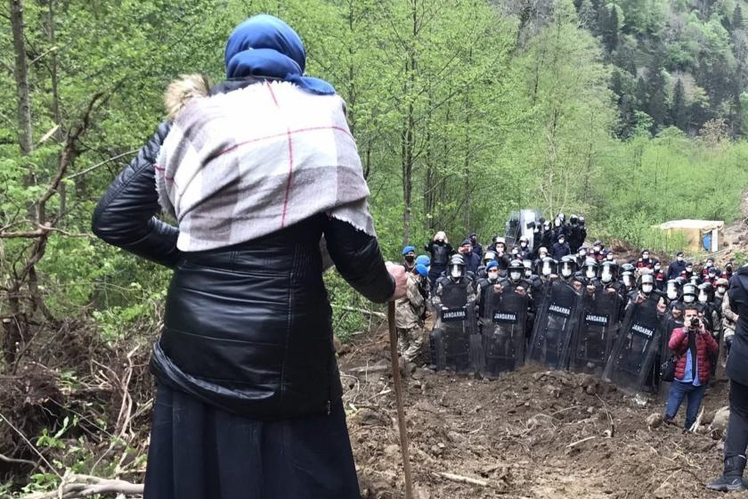 ikizderede bir kadın tepelik bir yerde değneğine yaslanarak aşağıdaki jandarmaya bakıyor. 