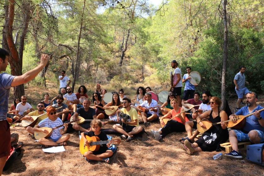 Ormanlık alanda bağlama ve gitar çalan kişiler