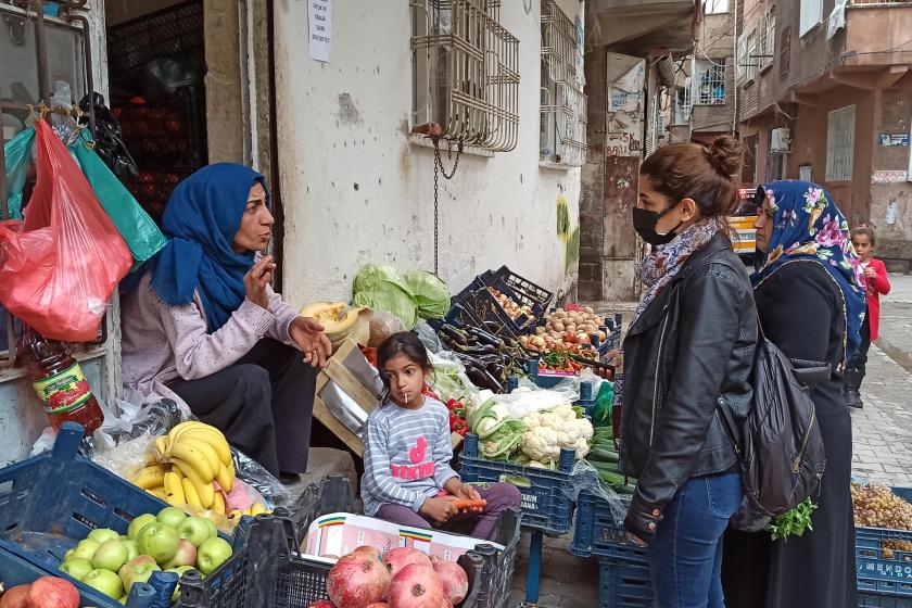 Manavın önünde kadınlarla sohbet eden muhabir