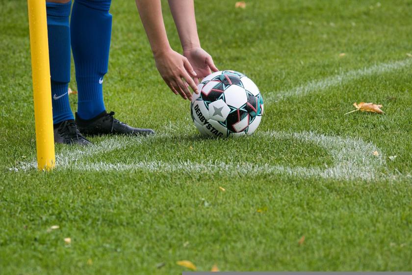 Sadece ayakları görünen bir futbolcu topu yere koyuyor.