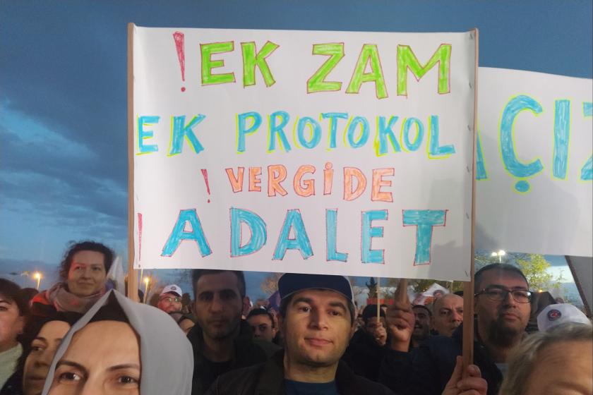 Elinde 'Ek zam, ek protokol, vergide adalet' yazılı döviz tutan işçi