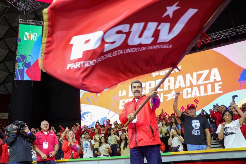 Nicolas Maduro partisinin bayrağını sallarken