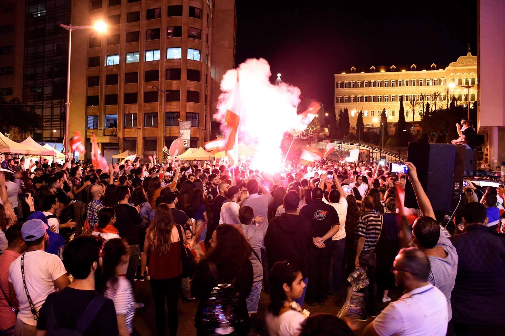 Lübnan'ın başkenti Beyrut'un merkezinde toplanan kalabalık meşaleler yakmış, slogan atıyor.