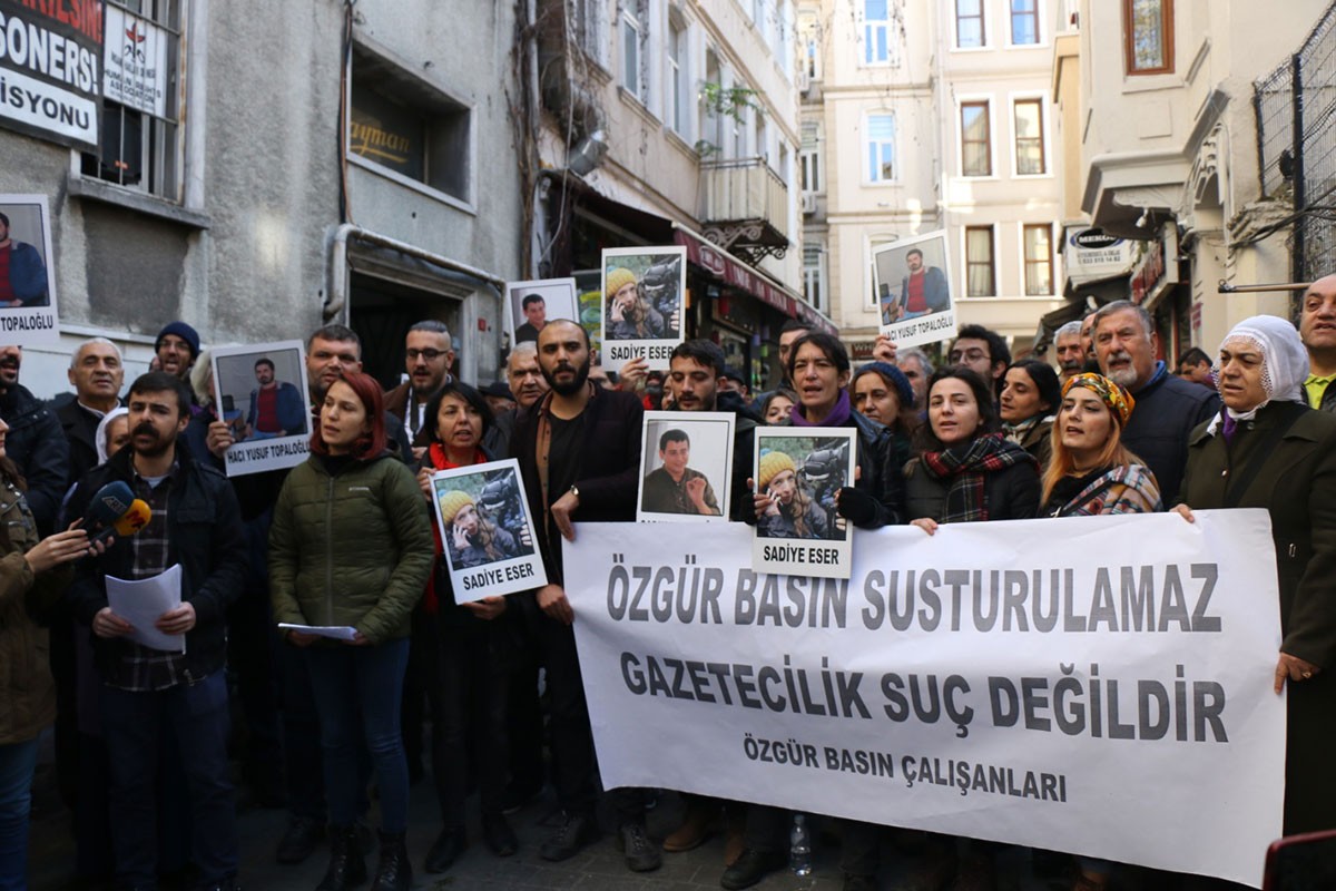 Çok sayıda gazeteci gazetecilik suç değildir pankartı arkasında toplanmış, tutuklu arkadaşlarının fotoğraflarını taşıyor.