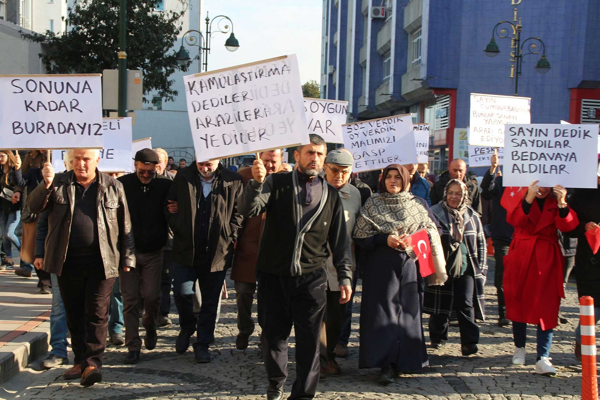 Vatandaşlar ellerinde dövizlerle kamulaştırma bedellerini protesto ediyor. 