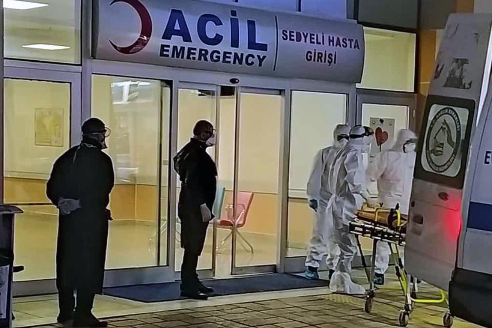 Koruyucu elbiselerle ambulanstan sedye ile hasta indiren sağlık görevlileri