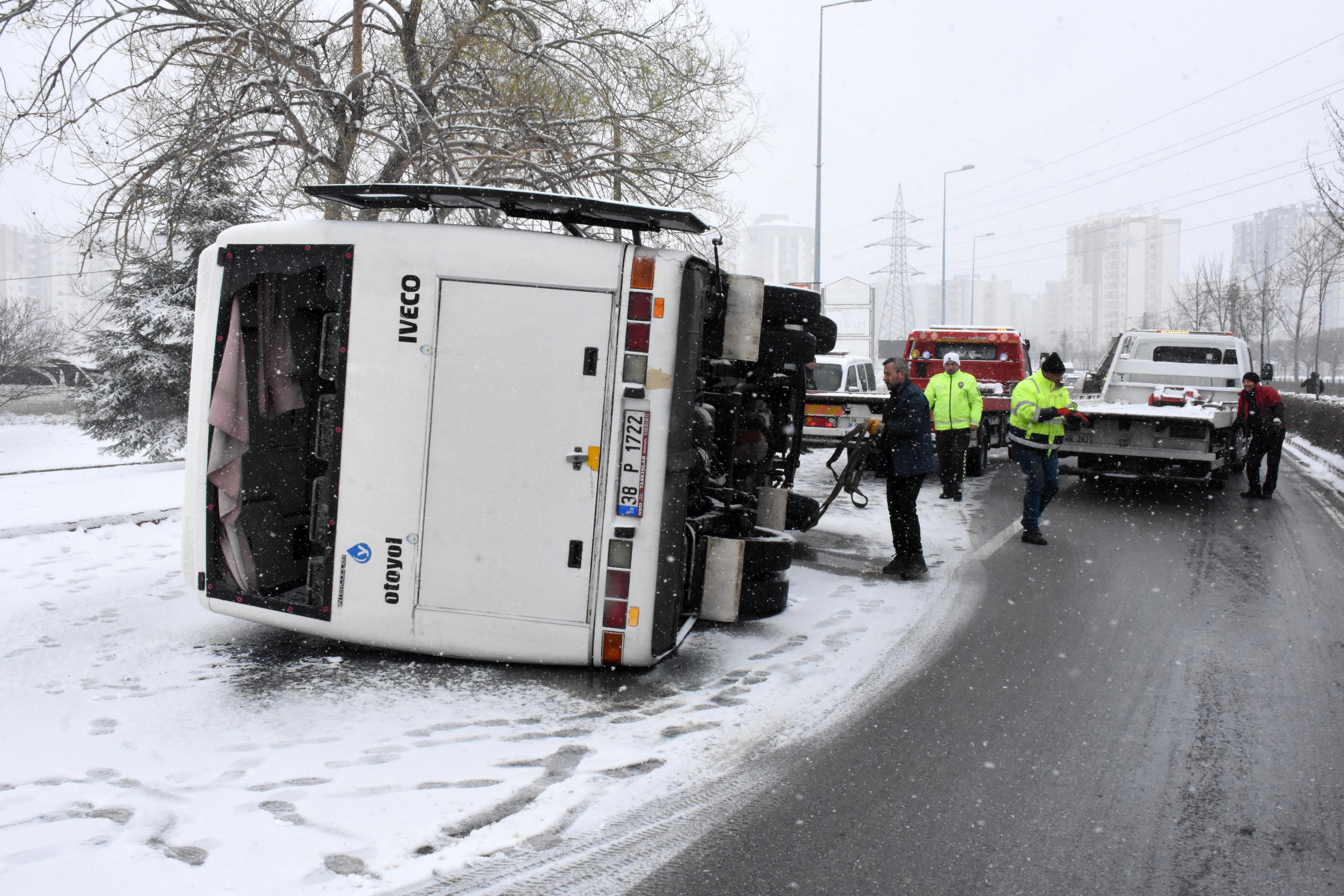 kaza yapan işçi servisi yan yatmış. çekici ekipleri ve trafik polisi aracın başında