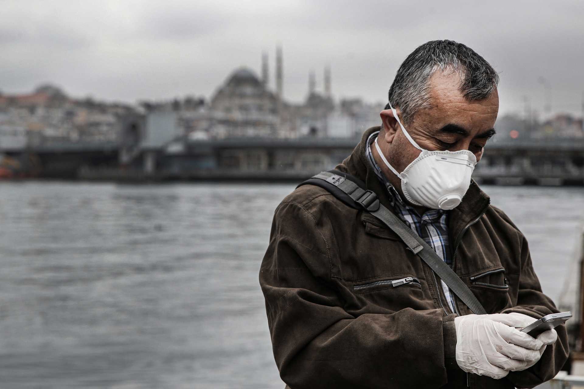 Koronavirüs (Kovid-19) salgını dolayısıyla İstanbul'da alınan önlemler sonrası yüzünde maske ve ellerinde eldiven olan bir yurttaş boş olan sahilde dururken.