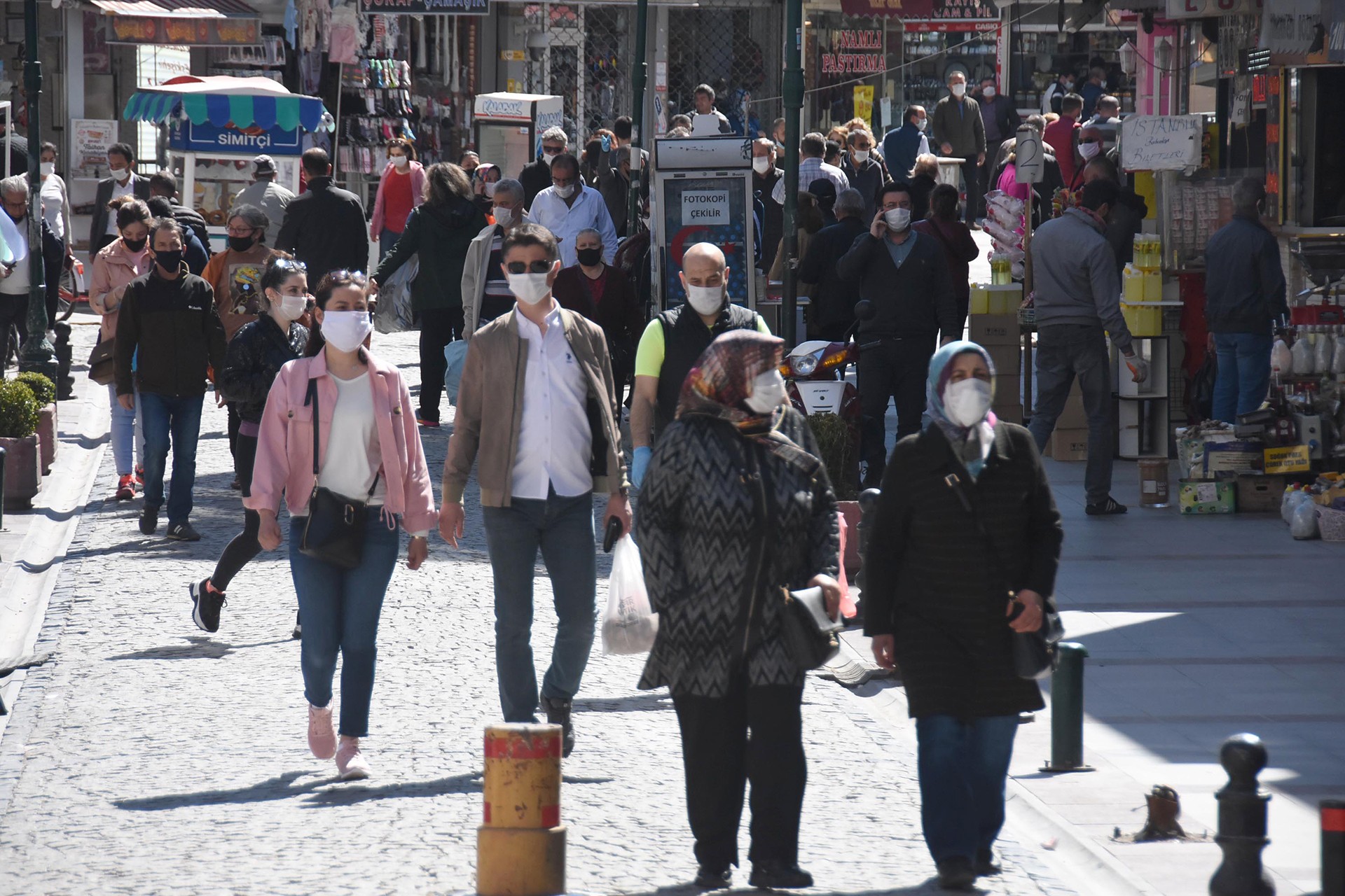 Sokakta yürüyen maskeli insanlar