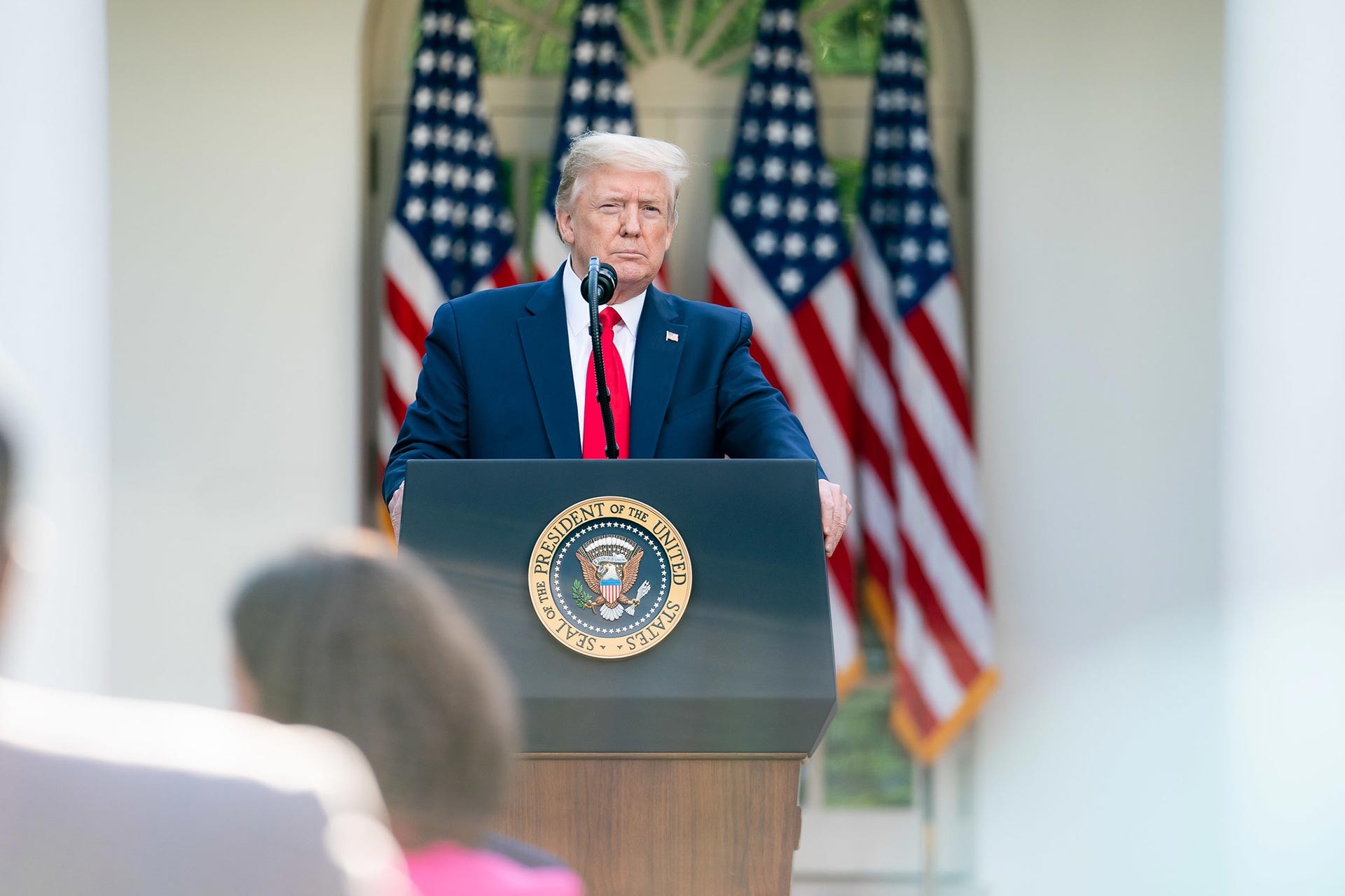 ABD Başkanı Donald Trump ABD bayrakları önünde konuşma yapıyor.