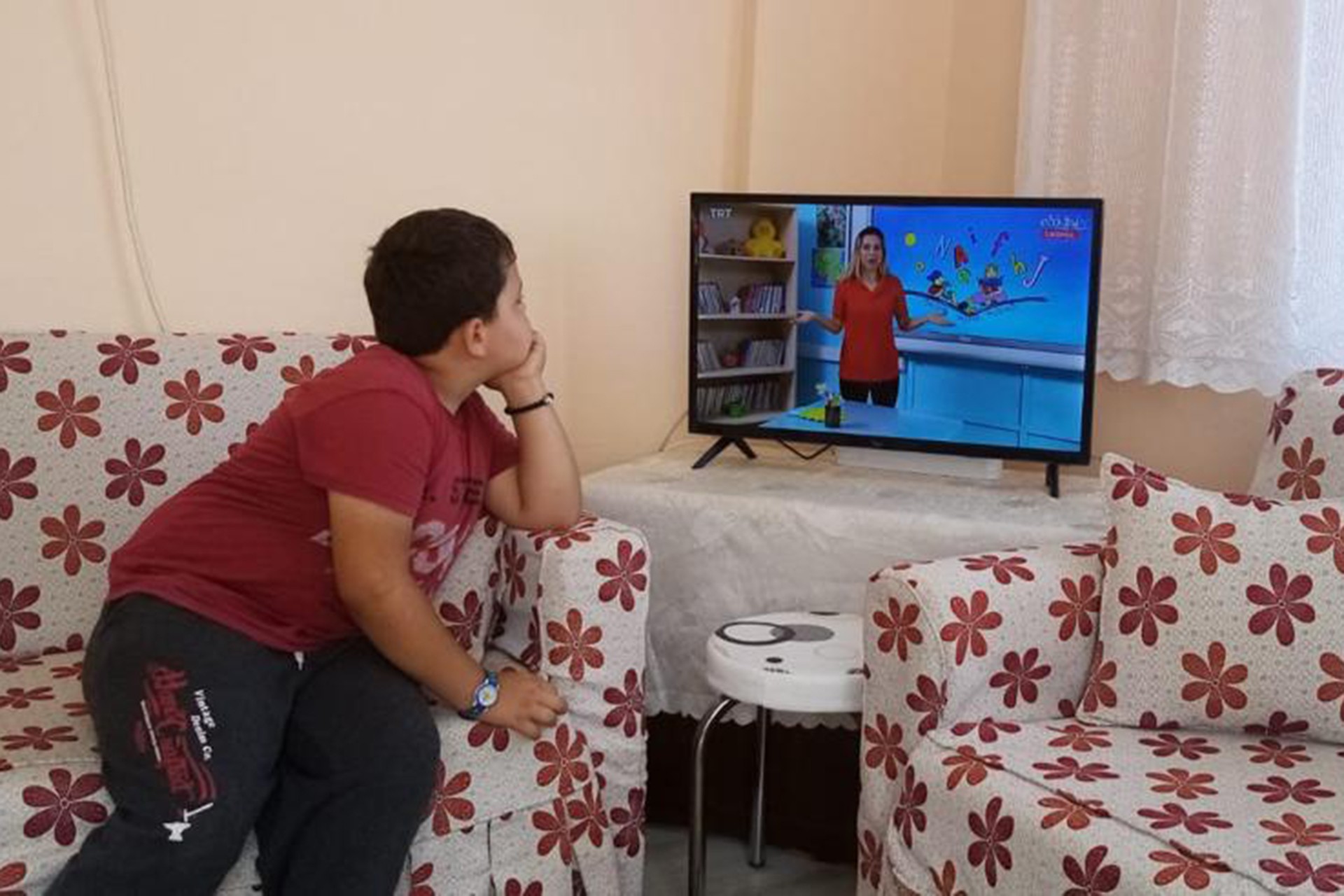 Evinde EBA TV izleyen bir çocuk.