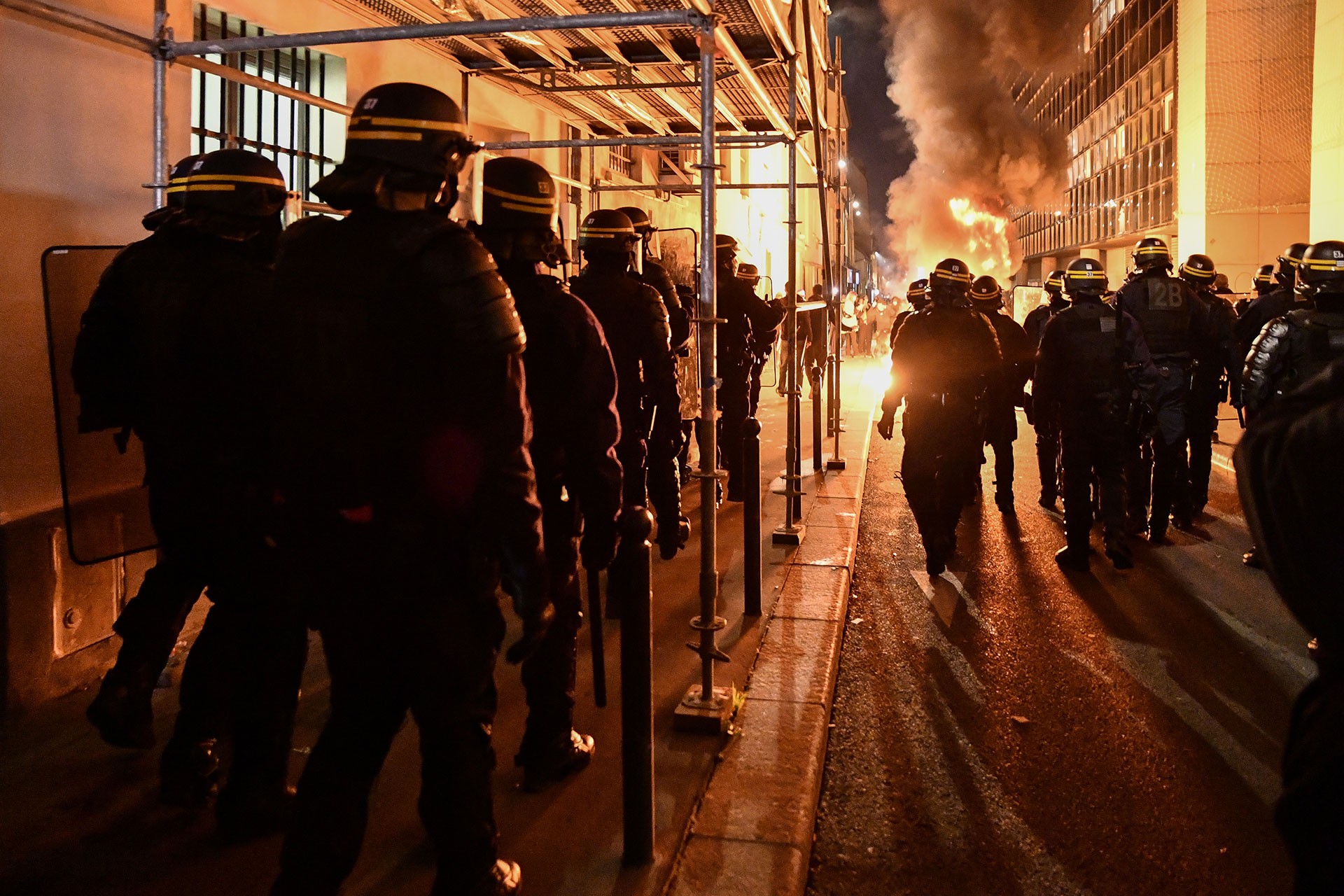 Çok sayıda polis ve yükselen alevler.