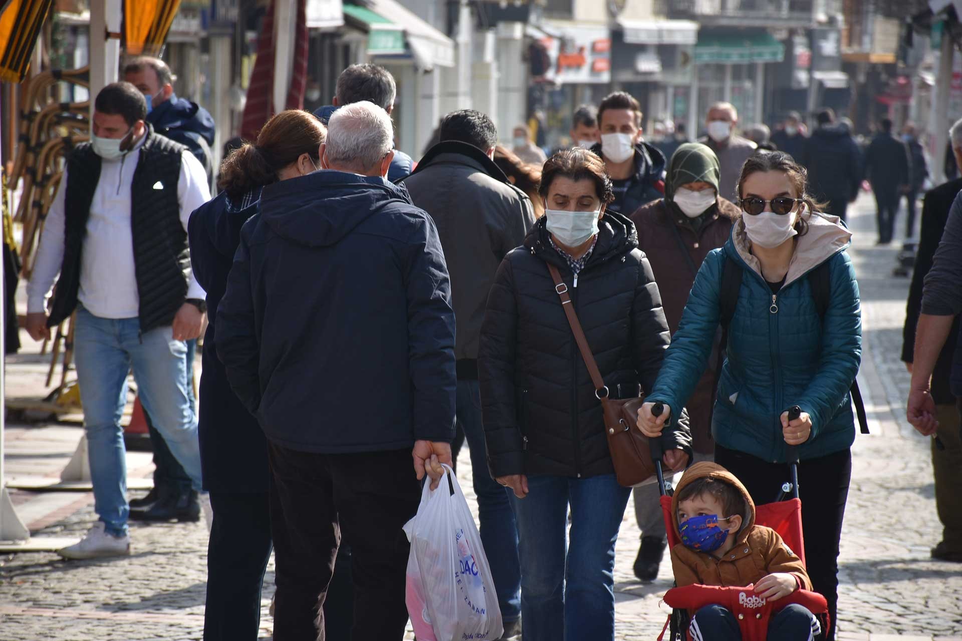 Kovid-19 sebebiyle maske ile yürüyen yurttaşlar