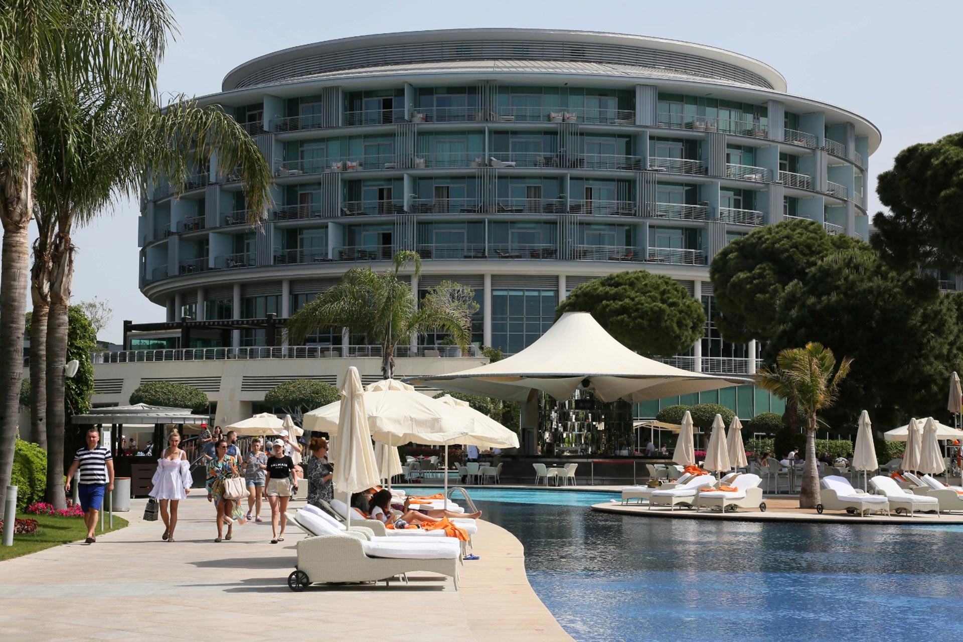 Otel binası, havuz (sağda) ve otelde kalan turistler (solda)