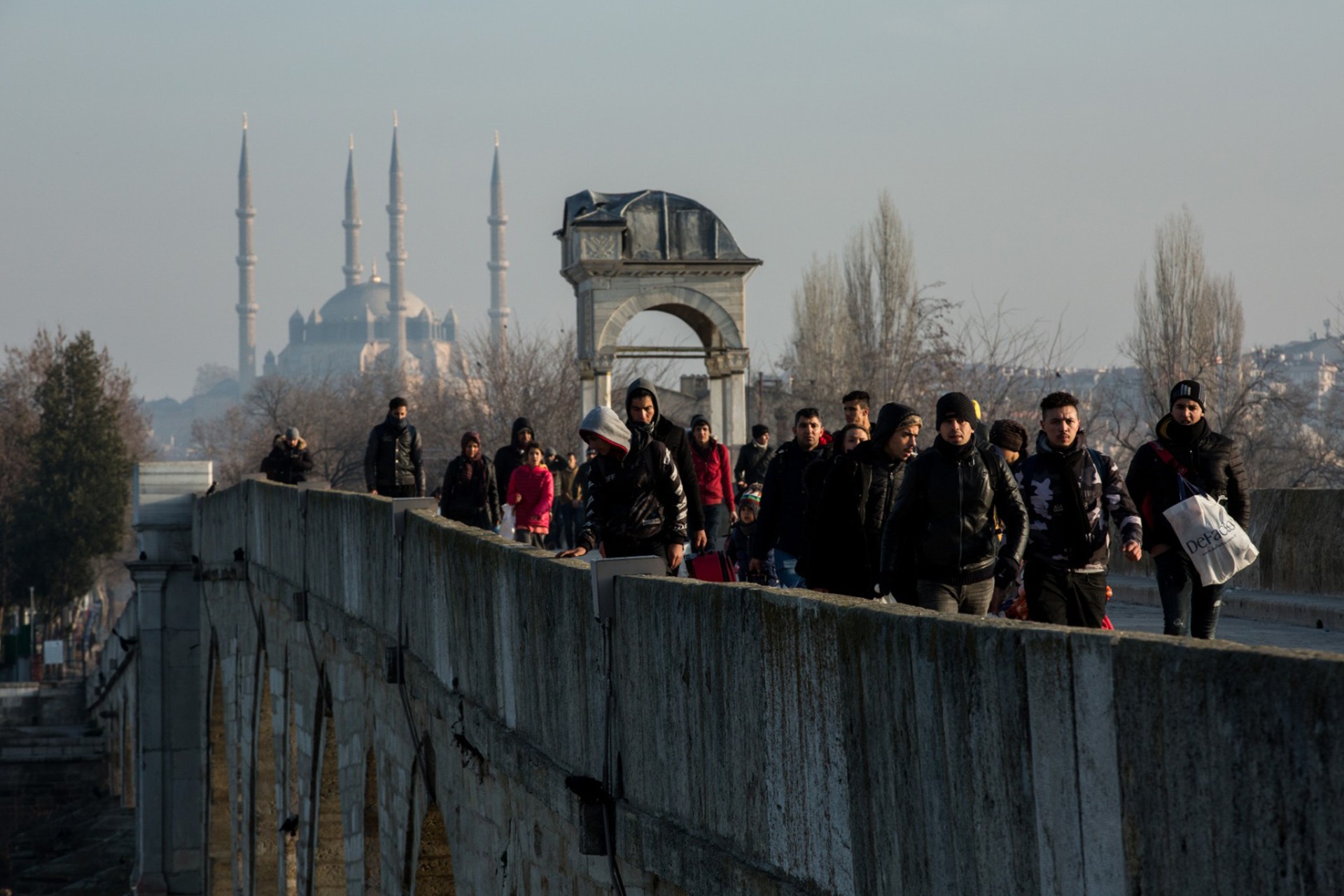 Köprüden yürüyerek geçen mülteciler