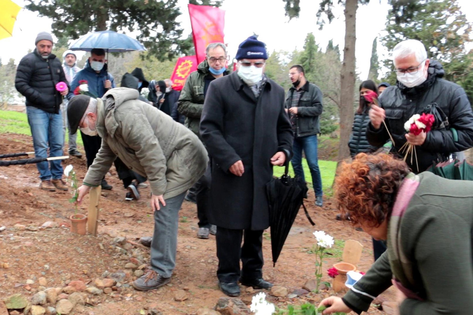 Emek Partisi (EMEP) İzmir İl Örgütü üyeleri katledilen 3 suriyeli işçinin mezarına çiçek bırakırken.