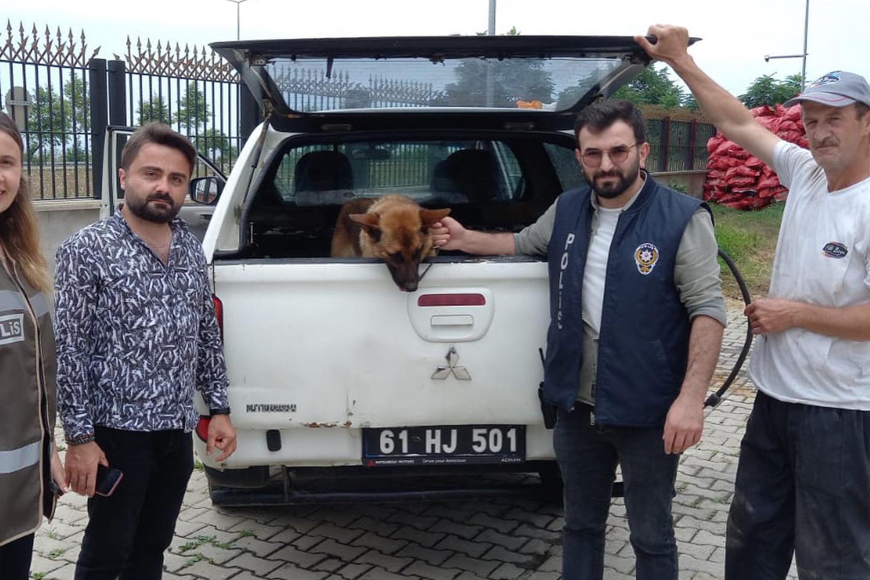 Fotoğrafta arabanın bagajında tutulan köpek ve polisler görünüyor 