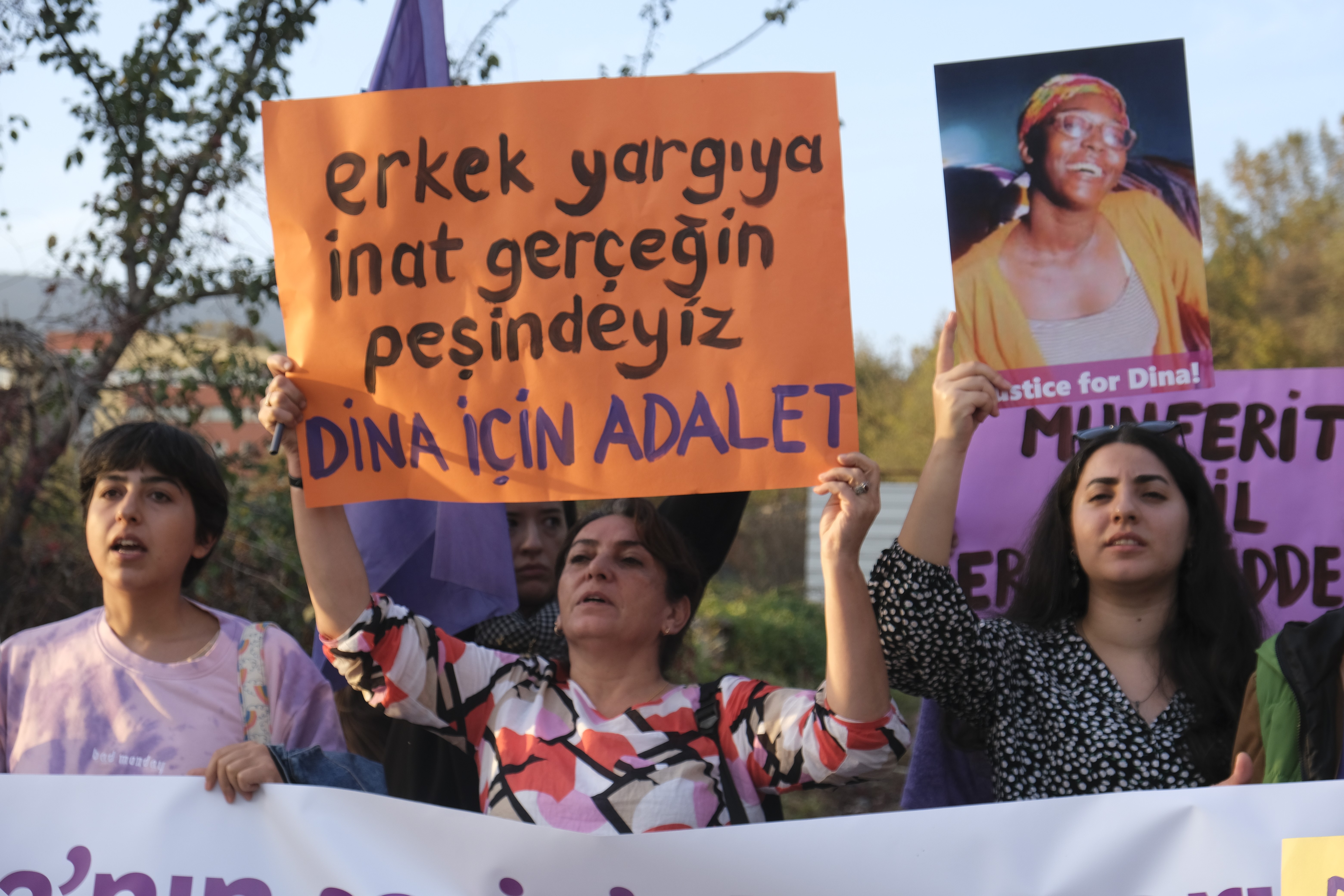 Ellerinde Dina için sloganların yazılı olduğu pankartları tutan kadınlar